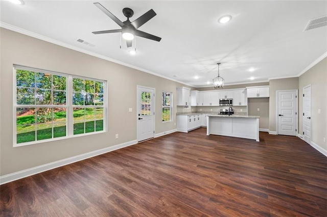 kitchen with a kitchen island, white cabinets, hanging light fixtures, and dark hardwood / wood-style flooring