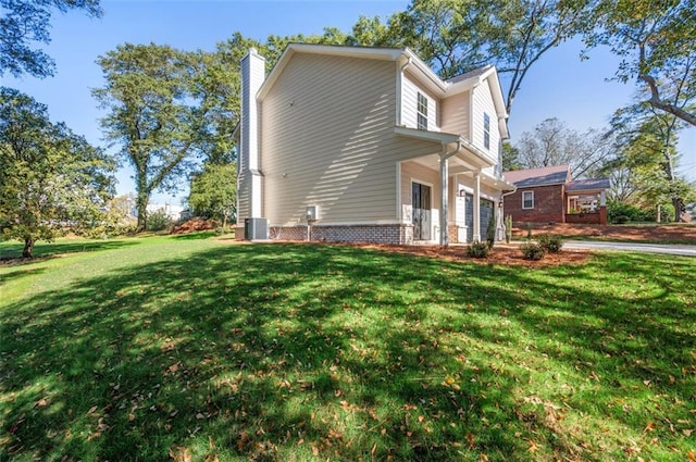 view of side of home featuring central AC and a lawn