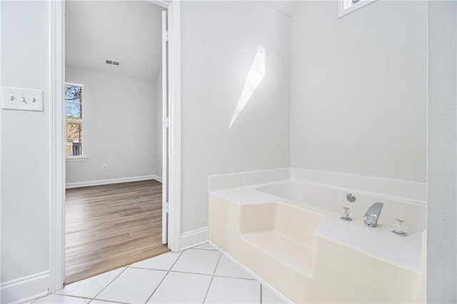 bathroom with baseboards, visible vents, a bath, and tile patterned floors