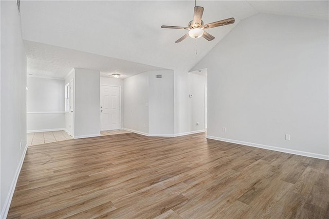 unfurnished room with light wood-style floors, high vaulted ceiling, baseboards, and a ceiling fan