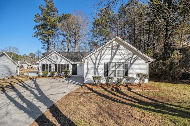 ranch-style house featuring a front yard and concrete driveway