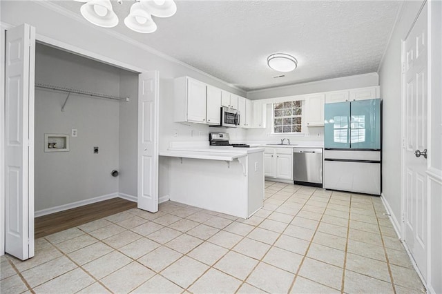 kitchen with a breakfast bar area, a peninsula, stainless steel appliances, white cabinetry, and light countertops