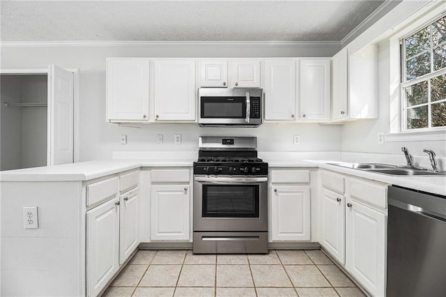 kitchen with appliances with stainless steel finishes, light countertops, and white cabinets