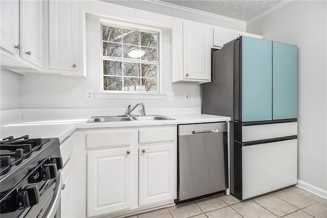 kitchen with stainless steel appliances, white cabinets, light countertops, and a sink