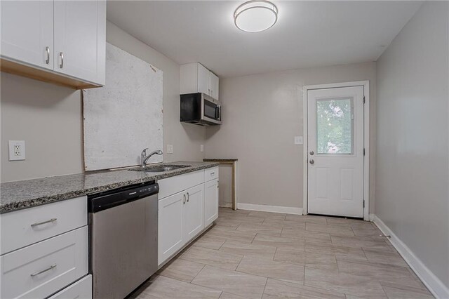941 Reed Ave, Atlanta, GA 30344 - kitchen with appliances with stainless steel finishes, a sink, stone countertops, white cabinets, and baseboards