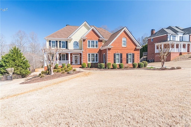 view of front of house featuring brick siding and covered porch