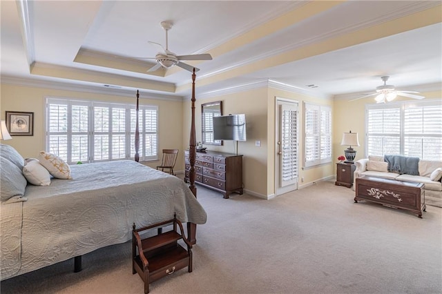 bedroom featuring carpet flooring, multiple windows, a tray ceiling, and ornamental molding