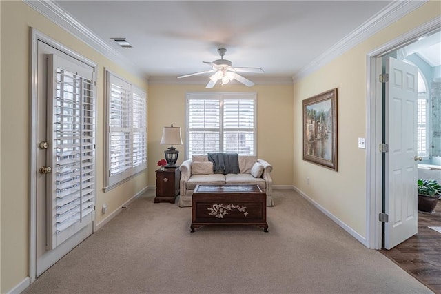 living area with visible vents, baseboards, and ornamental molding