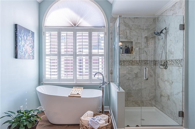 full bathroom featuring plenty of natural light, a shower stall, and a freestanding bath