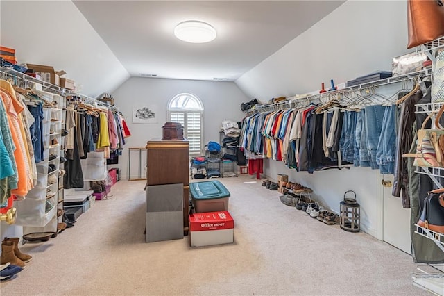 spacious closet featuring visible vents, carpet flooring, and vaulted ceiling