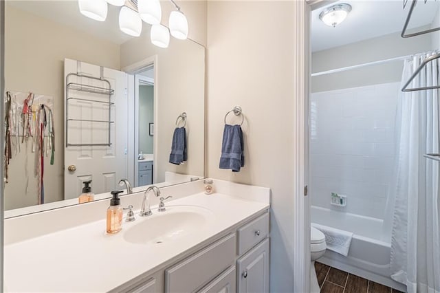 bathroom with vanity, toilet, wood finished floors, and shower / bath combo