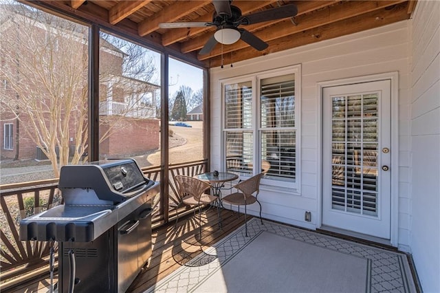 sunroom with a wealth of natural light, beamed ceiling, and ceiling fan