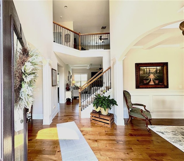 4745 Belcrest Way, Cumming, GA 30040 - entrance foyer featuring arched walkways, stairway, a high ceiling, and wood finished floors
