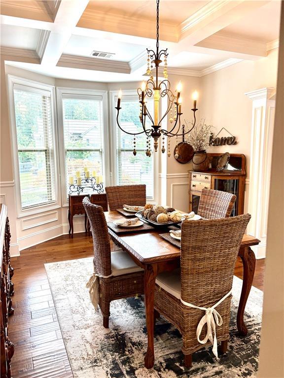 4745 Belcrest Way, Cumming, GA 30040 - dining area with a chandelier, coffered ceiling, beamed ceiling, a decorative wall, and dark wood-style flooring