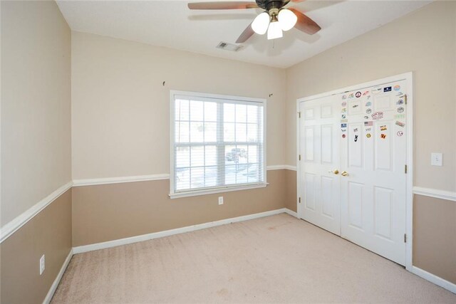 unfurnished bedroom featuring ceiling fan and light carpet