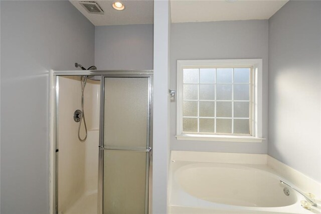 bathroom with separate shower and tub and a healthy amount of sunlight