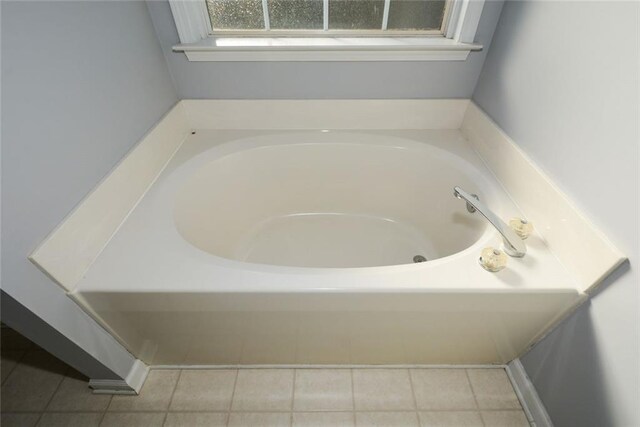 bathroom with tile patterned floors and a tub