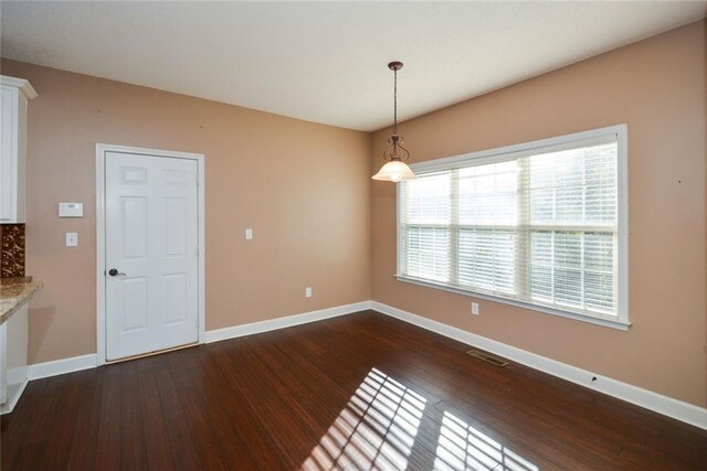 unfurnished dining area with dark hardwood / wood-style flooring