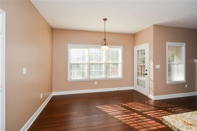 unfurnished dining area featuring dark hardwood / wood-style floors