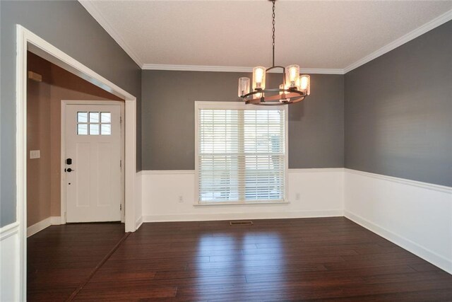 foyer with dark hardwood / wood-style floors, an inviting chandelier, and ornamental molding