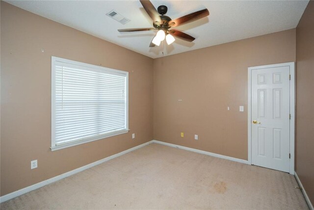 spare room featuring light colored carpet and ceiling fan