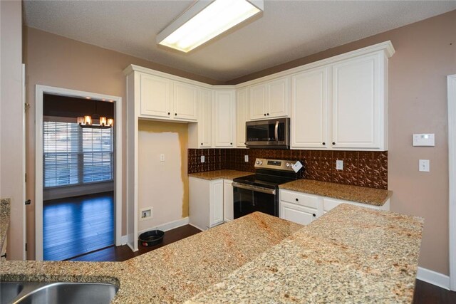 kitchen with appliances with stainless steel finishes, dark hardwood / wood-style flooring, and white cabinetry