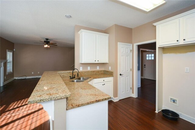 kitchen with white cabinetry, sink, kitchen peninsula, and dark wood-type flooring