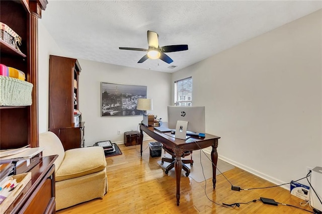 home office featuring ceiling fan, a textured ceiling, and light wood-type flooring