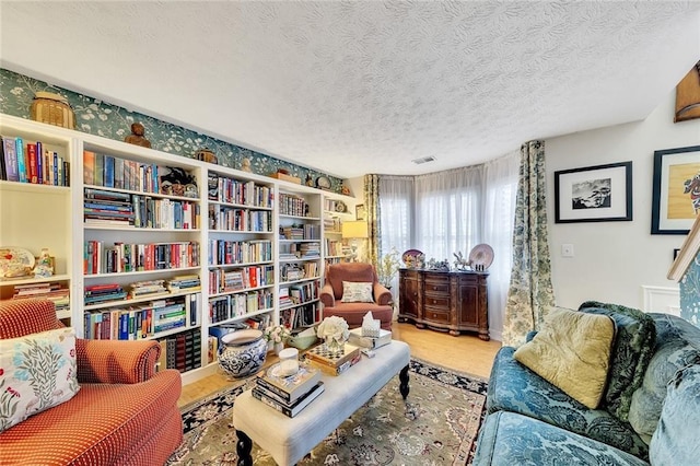 living area featuring wood-type flooring and a textured ceiling