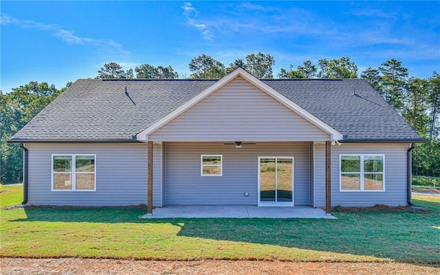rear view of property with a yard, a patio, a ceiling fan, and a shingled roof