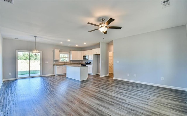 kitchen featuring visible vents, baseboards, open floor plan, a ceiling fan, and appliances with stainless steel finishes