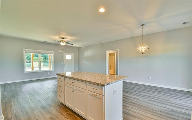 kitchen featuring a center island, open floor plan, baseboards, light wood-type flooring, and visible vents