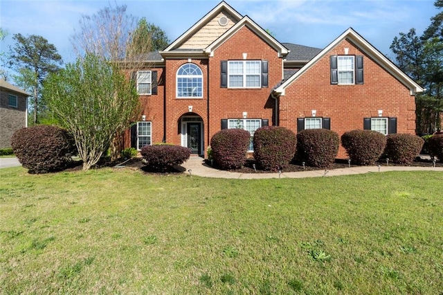 view of front of property with a front lawn and brick siding