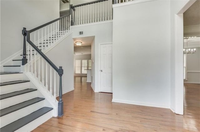 foyer entrance with a notable chandelier, a high ceiling, and light hardwood / wood-style floors