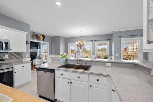 kitchen featuring a sink, decorative backsplash, light countertops, white cabinets, and stainless steel appliances