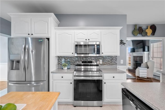 kitchen featuring white cabinetry, light countertops, backsplash, and stainless steel appliances