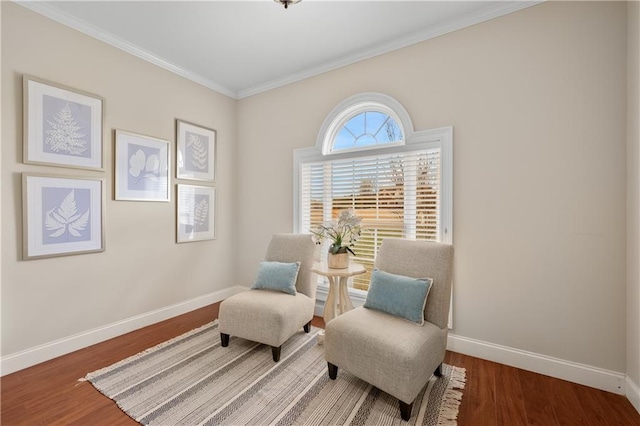 living area featuring baseboards, wood finished floors, and crown molding