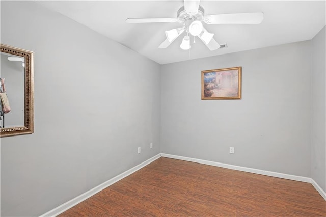 empty room featuring a ceiling fan, wood finished floors, and baseboards