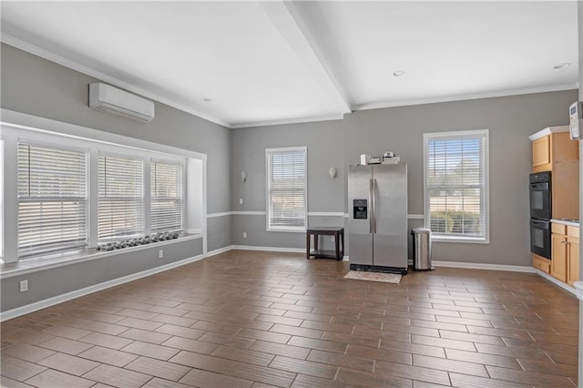 unfurnished living room with a wealth of natural light, wood finish floors, a wall mounted AC, and baseboards