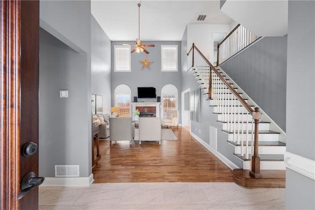 foyer entrance with visible vents, stairs, and a ceiling fan