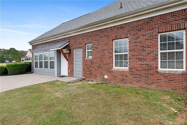 back of house with a patio area, a lawn, and brick siding