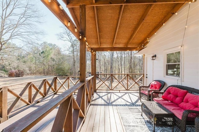 wooden terrace with an outdoor living space