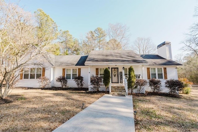 ranch-style home featuring covered porch and a chimney