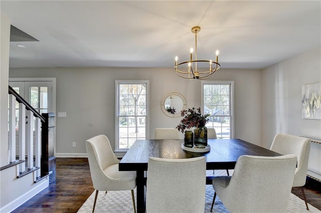 dining area with french doors, dark wood-type flooring, a wealth of natural light, and a chandelier