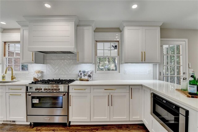 kitchen featuring a wealth of natural light, black microwave, and stainless steel stove