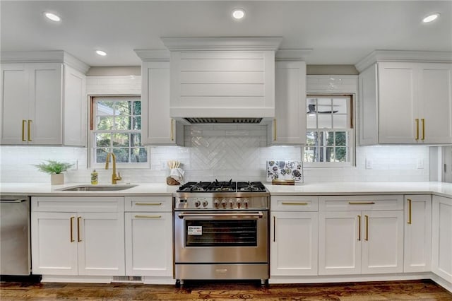 kitchen featuring backsplash, white cabinetry, sink, and appliances with stainless steel finishes