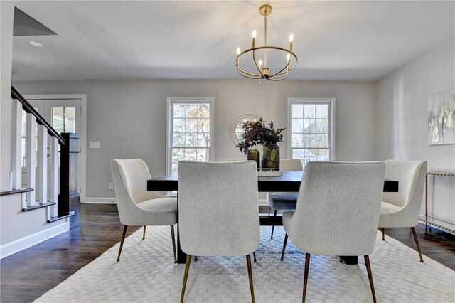 dining area with a notable chandelier, plenty of natural light, and dark hardwood / wood-style flooring