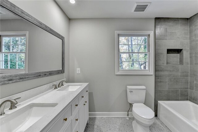 full bathroom with toilet, vanity, tile patterned floors, and tiled shower / bath combo