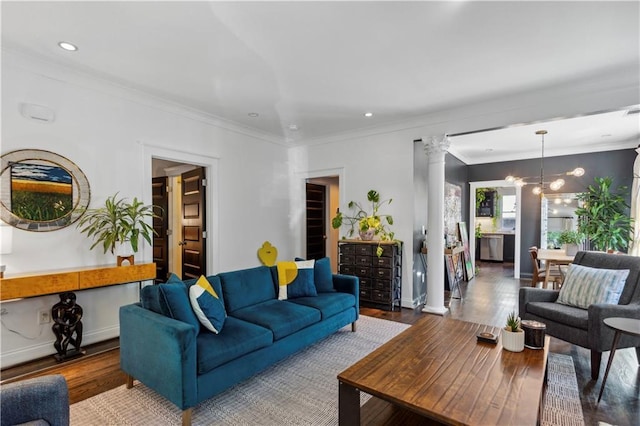 living room featuring a chandelier, wood-type flooring, decorative columns, and crown molding