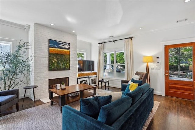 living room with dark hardwood / wood-style floors and a brick fireplace